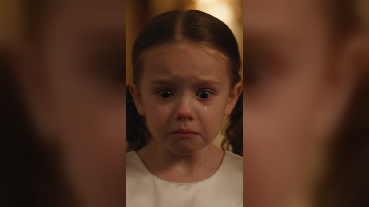 A tearful child receives comfort during a dramatized birthday scene