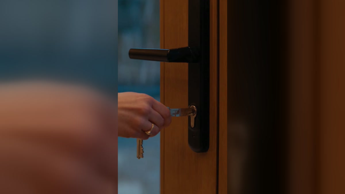 A dramatized winter patio scene with a woman waiting outside a glass door