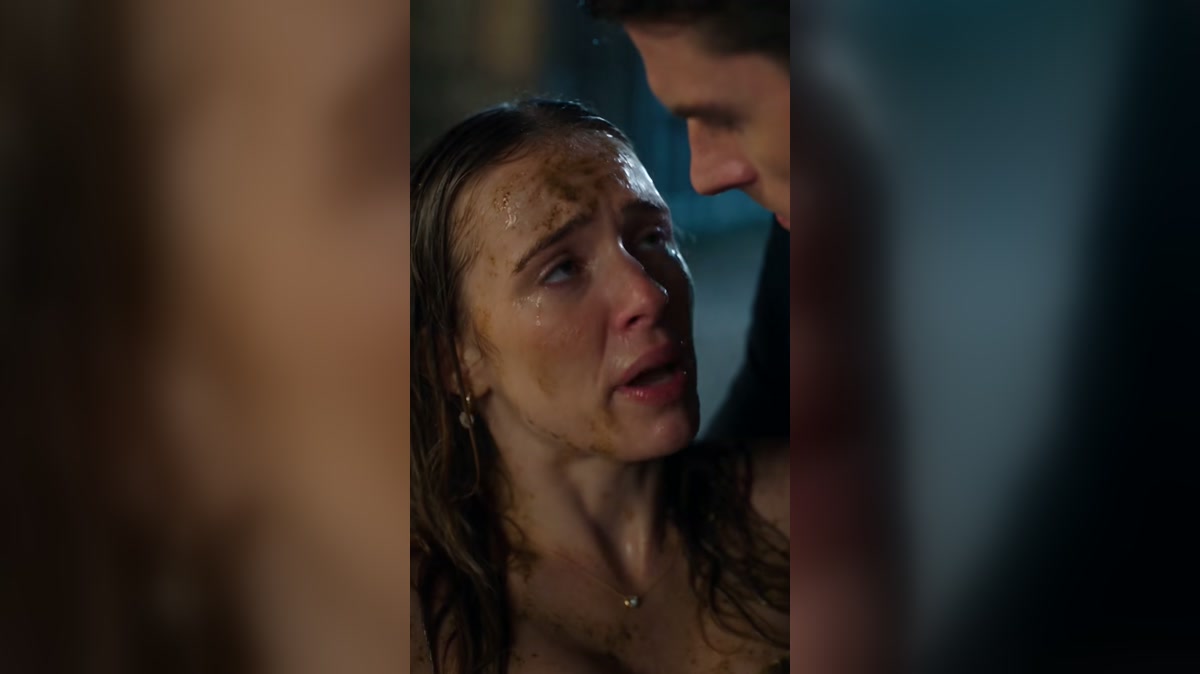 A woman is helped to safety after a frightening fall in heavy rain